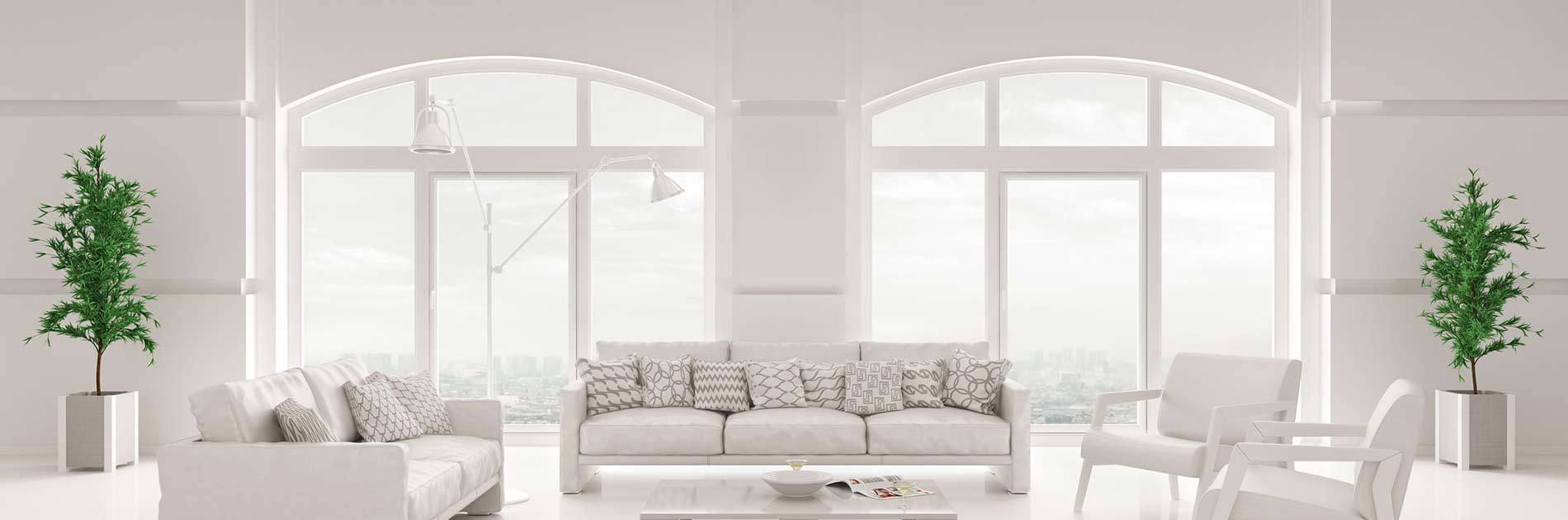 Contemporary white living room with large arched windows and neutral furniture.