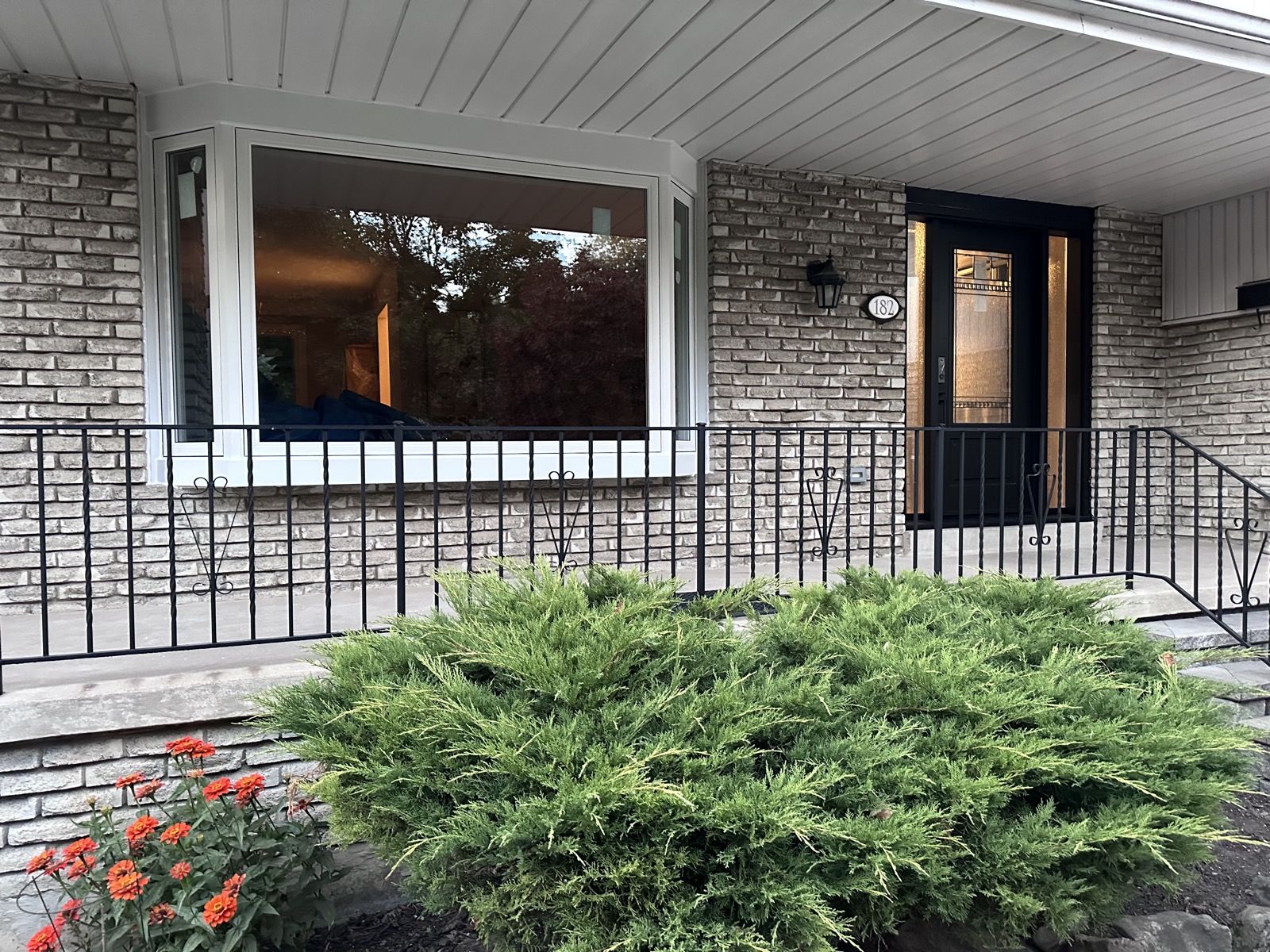Bay window on a stone bungalow installed by Optima Windows and Doors in the Greater Toronto Area