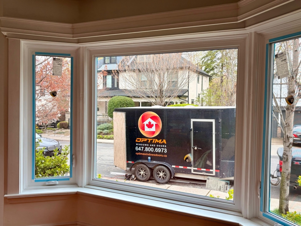 Bay window replacement viewed from inside, with an Optima installation trailer outside
