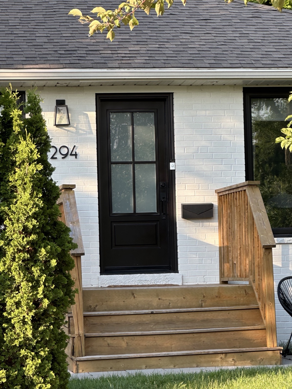Black entry door with wood accent siding installed by Optima Windows and Doors in the Greater Toronto Area