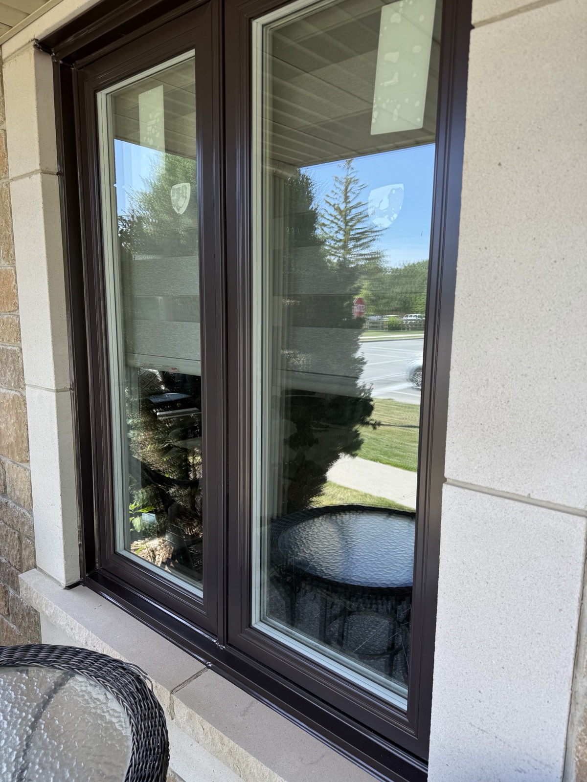Black framed window on a stone facade installed by Optima Windows and Doors in the Greater Toronto Area