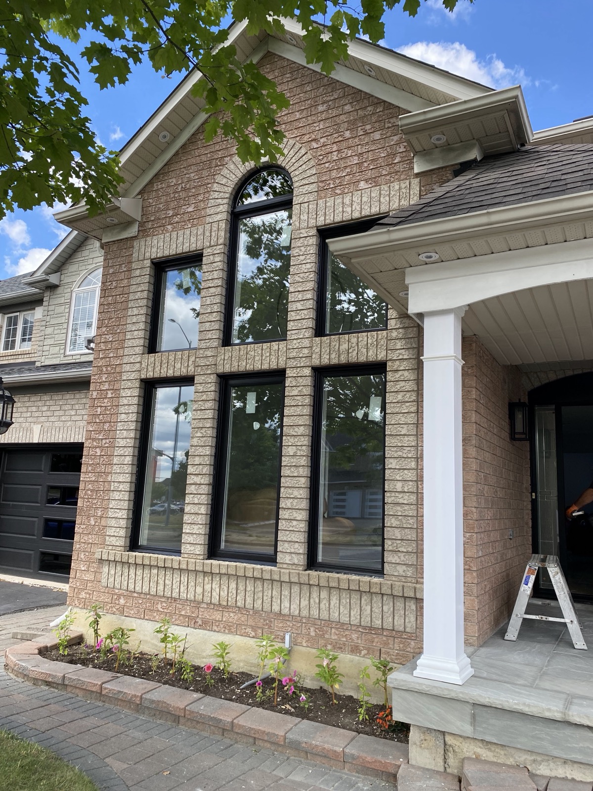 Black framed windows on a red brick home installed by Optima Windows and Doors in the Greater Toronto Area
