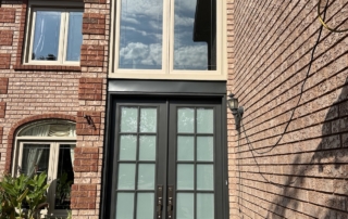 Black french patio doors and window on a brick home installed by Optima Windows and Doors in the Greater Toronto Area
