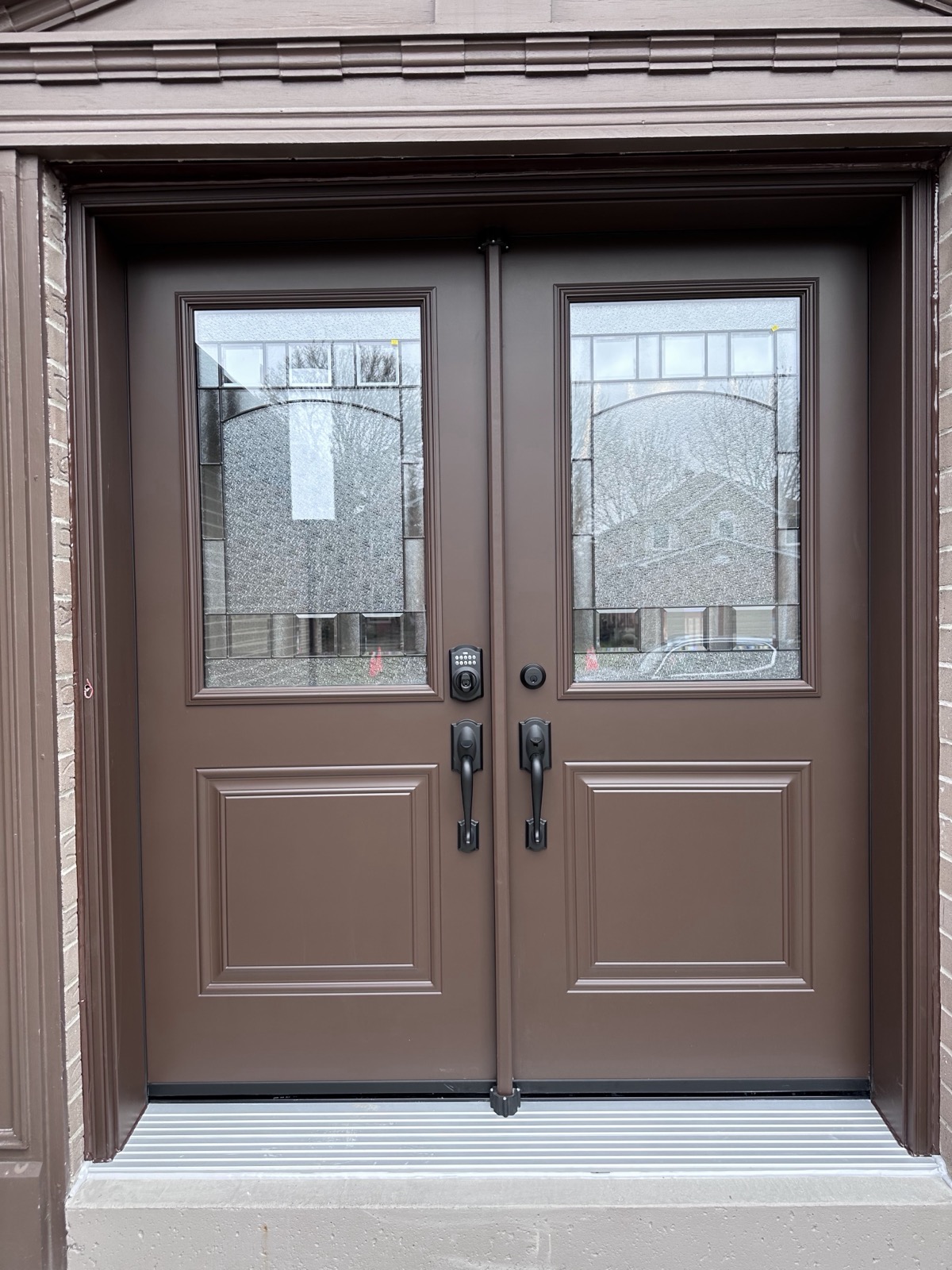 Brown double entry doors with decorative glass installed by Optima Windows and Doors in the Greater Toronto Area