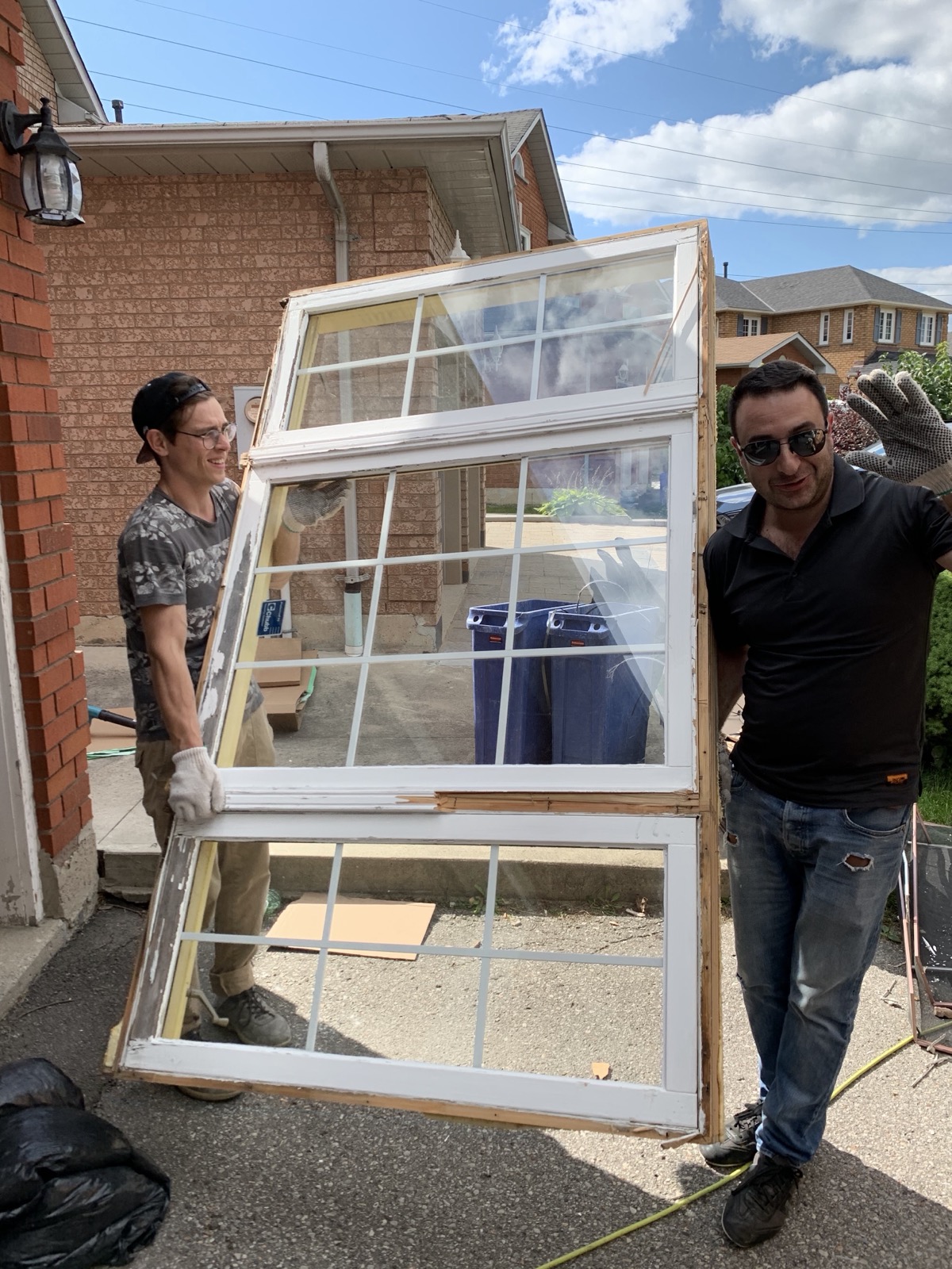 Optima crew carrying a new window on installation day installed by Optima Windows and Doors in the Greater Toronto Area