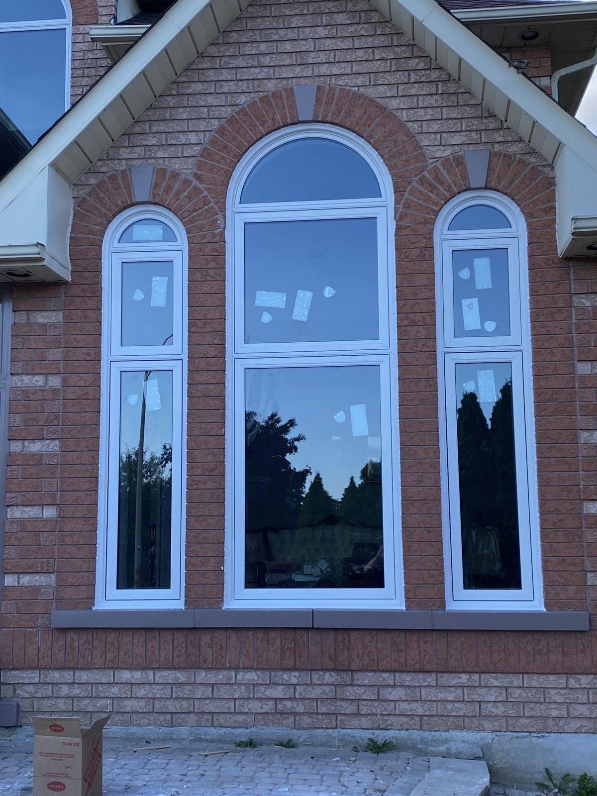 Tall arched windows on a brick home installed by Optima Windows and Doors in the Greater Toronto Area