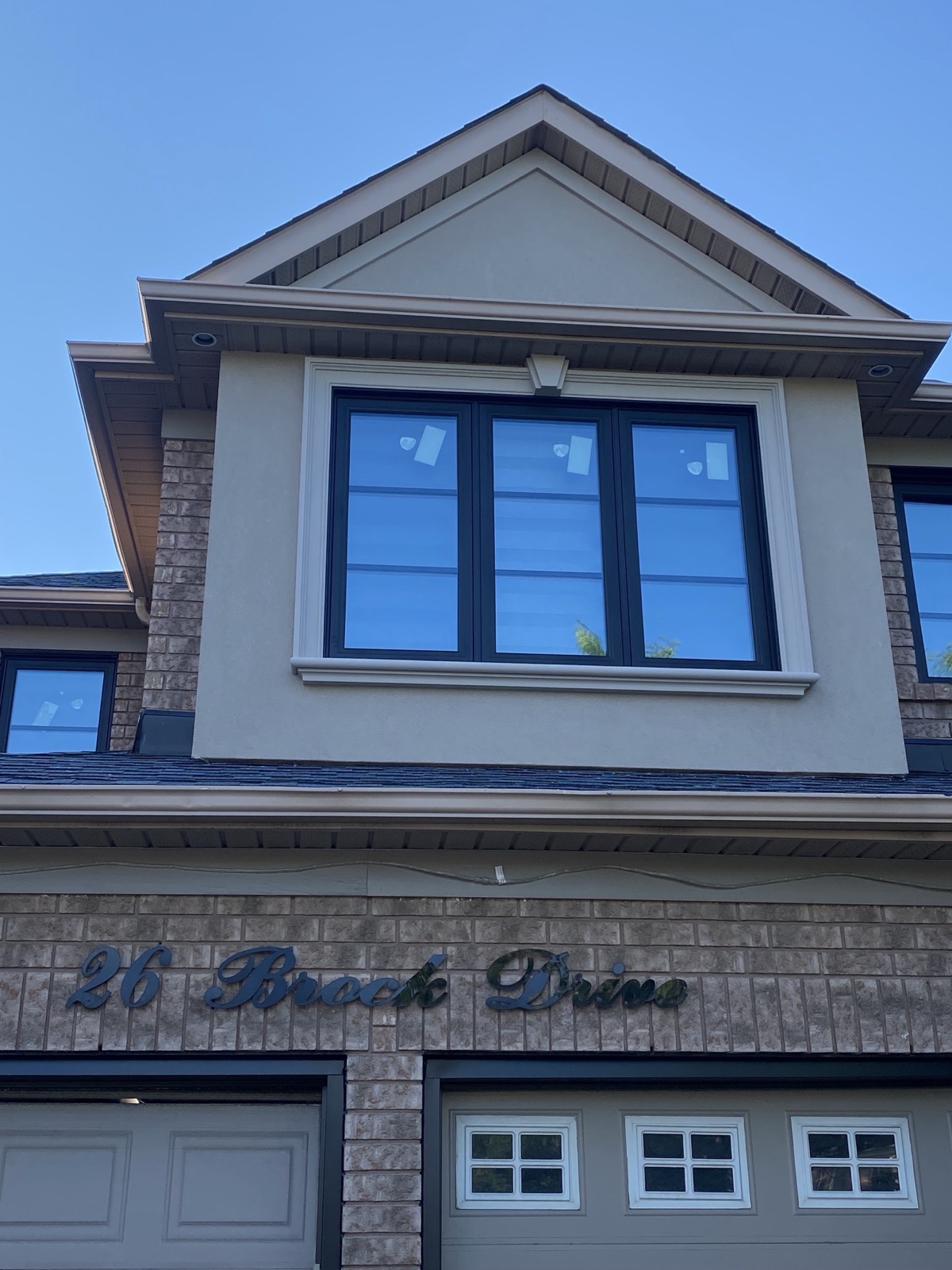 Upper storey black framed windows on a modern home installed by Optima Windows and Doors in the Greater Toronto Area