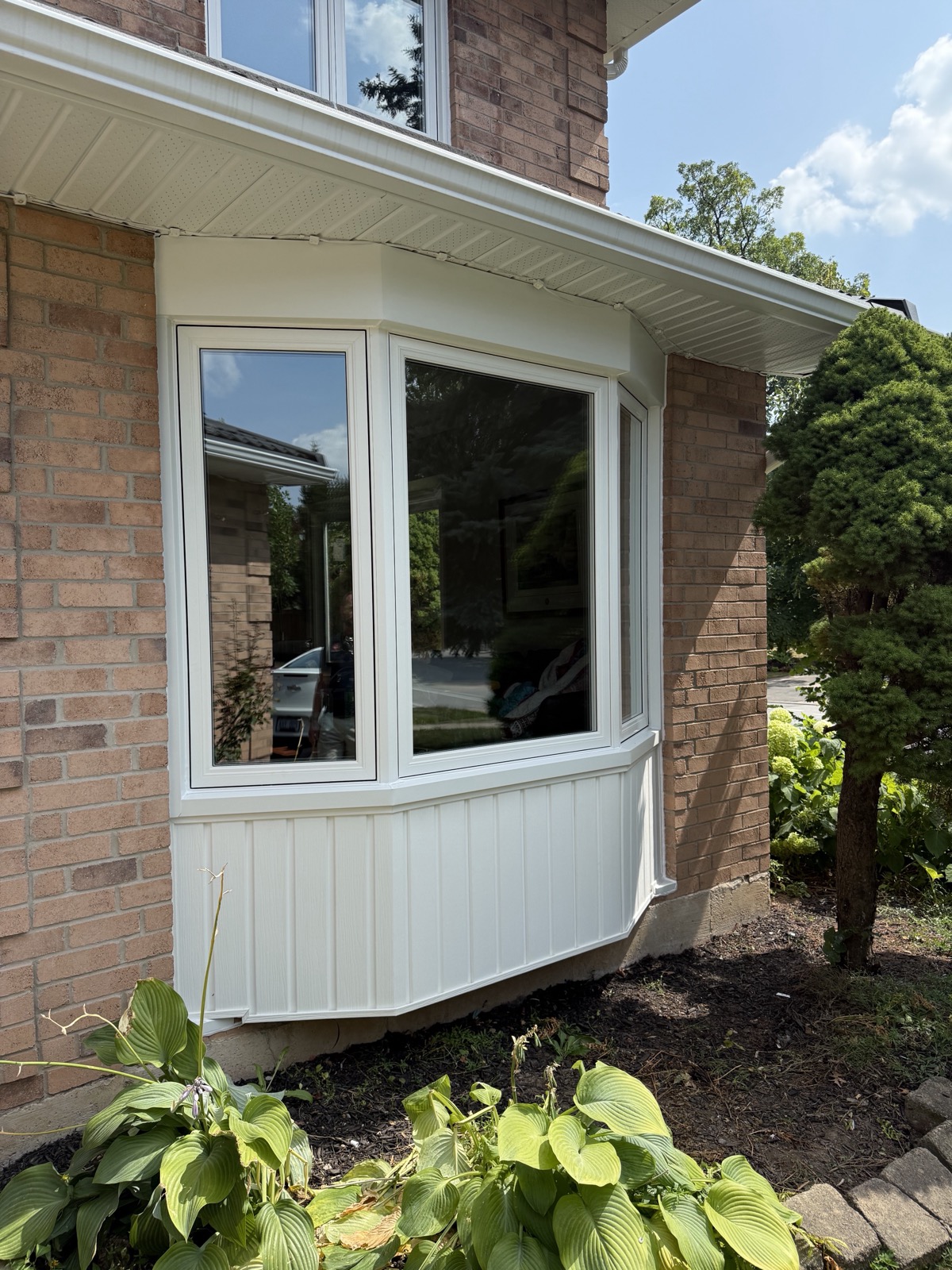 White bay window on a brick home installed by Optima Windows and Doors in the Greater Toronto Area
