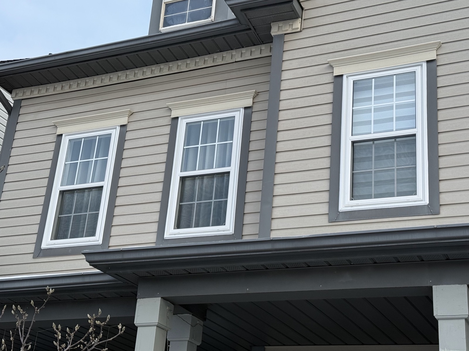 White double hung windows on grey siding installed by Optima Windows and Doors in the Greater Toronto Area