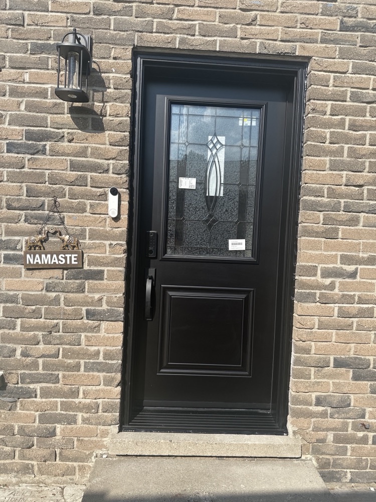 New black entry door with a decorative glass insert installed by Optima in a Kitchener home
